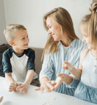 Imagen de una madre haciendo una manualidad con sus dos hijos sobre un escritorio