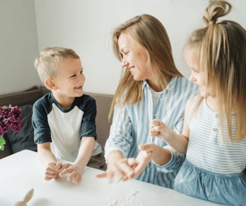Imagen de una madre haciendo una manualidad con sus dos hijos sobre un escritorio