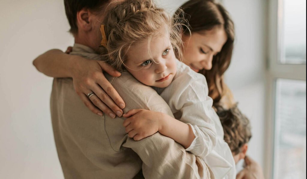 Padre y madre abrazando a su hija