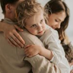 Padre y madre abrazando a su hija