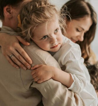 Padre y madre abrazando a su hija