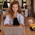 madre trabajando desde casa con su hijo jugando al lado ganar dinero desde casa sin invertir